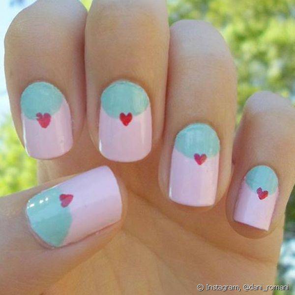 A nail art com esmaltes claros e com mini corações deixam as mãos perfeitas para comemorações durante o dia